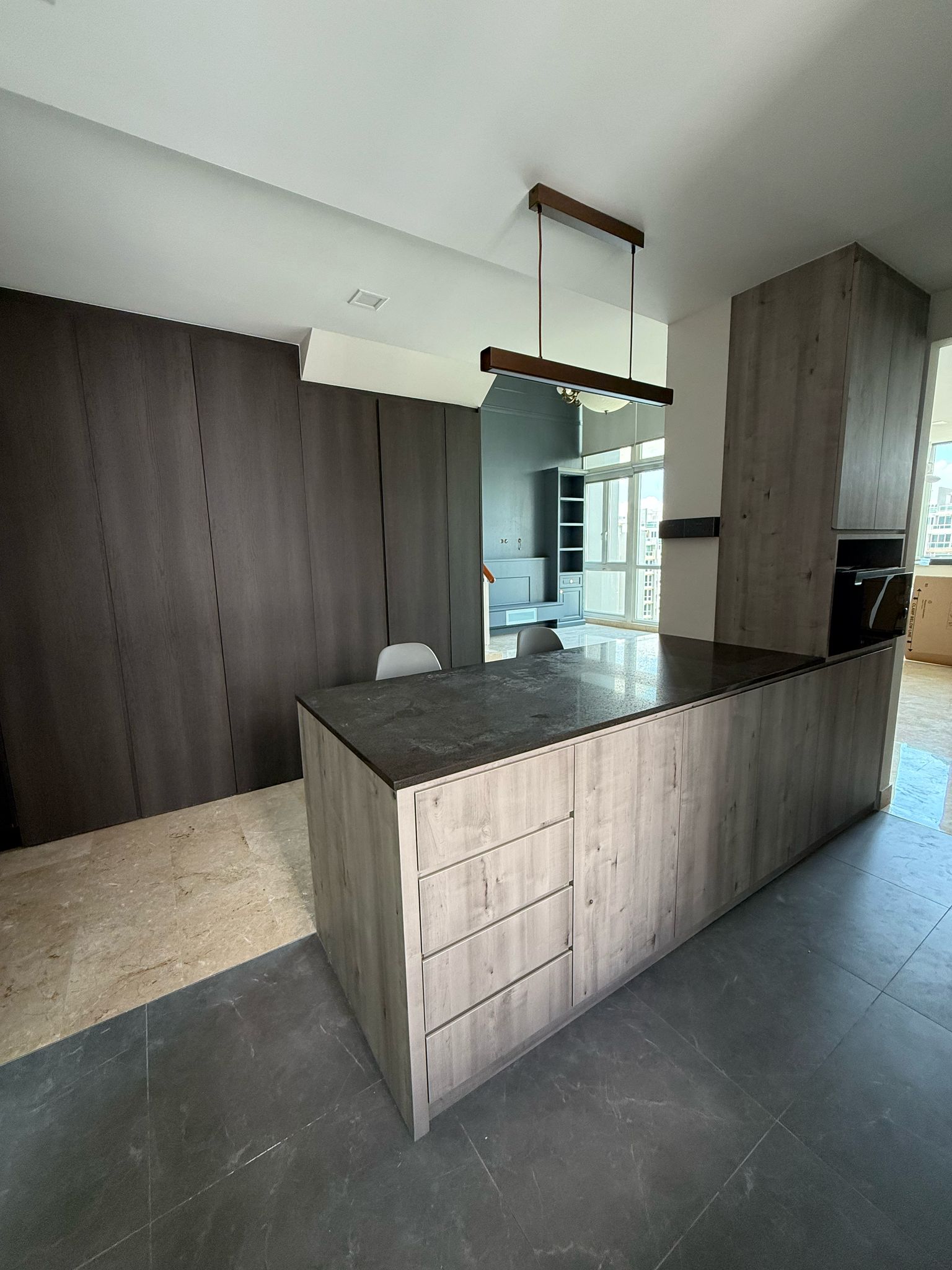 Modern dark-toned kitchen with island countertop and full-height cabinetry